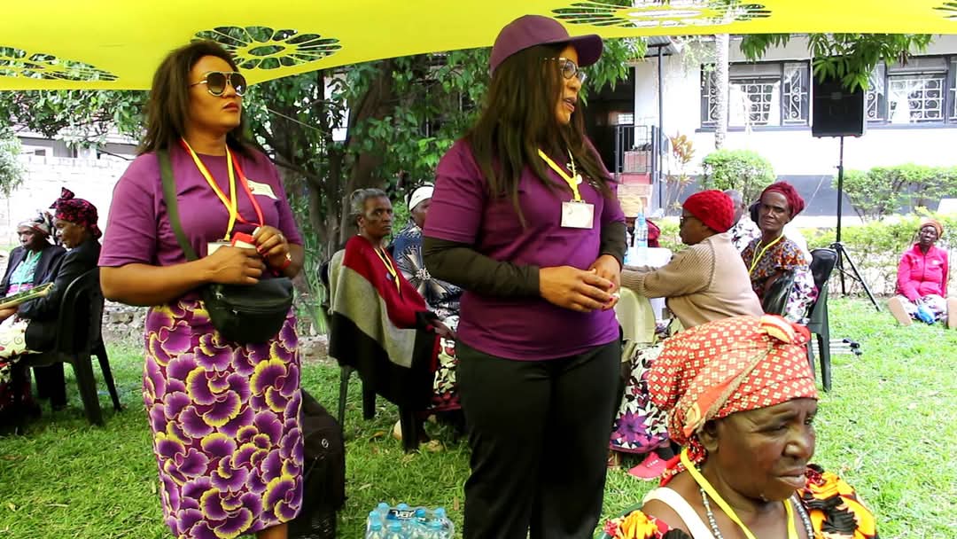 Community gathering under outdoor tent.