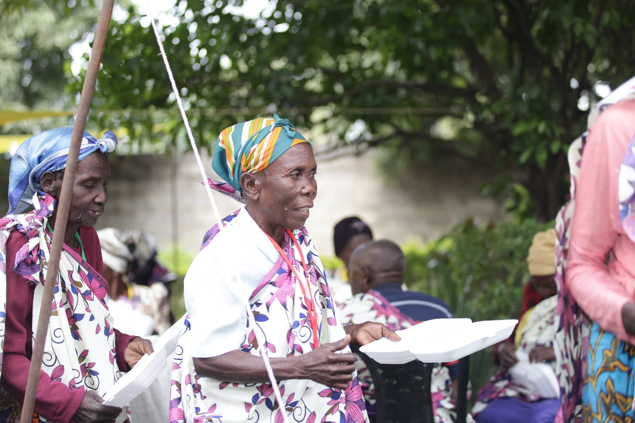 Elderly people lining up to get food.