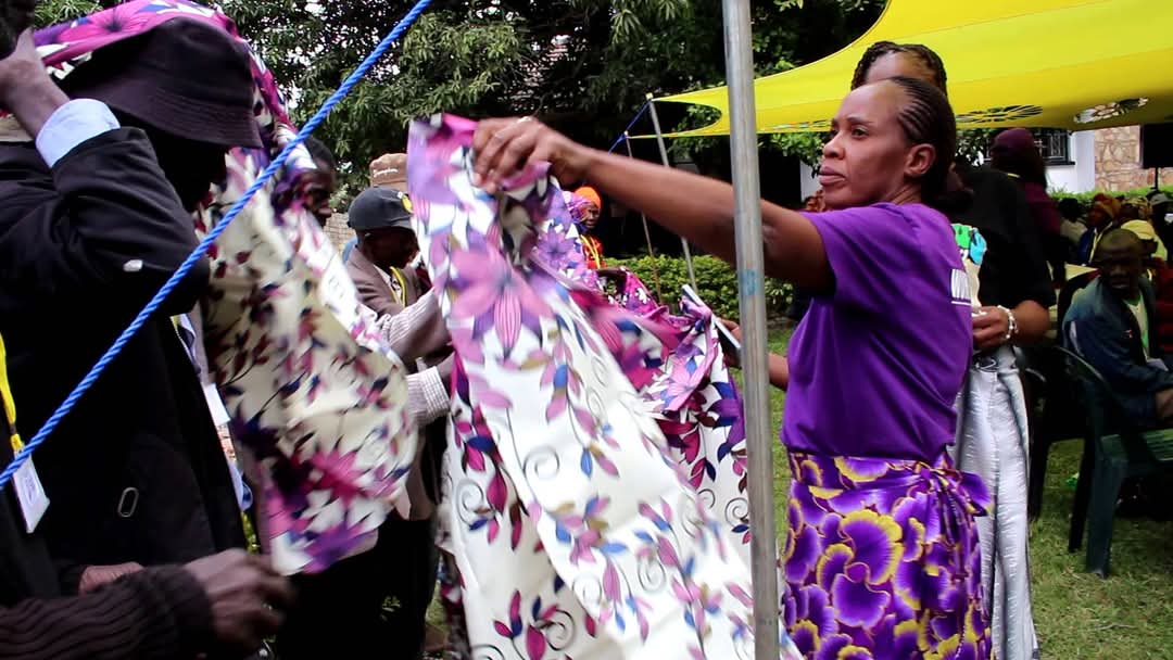 The volunteers are distributing floral cloth to everyone.