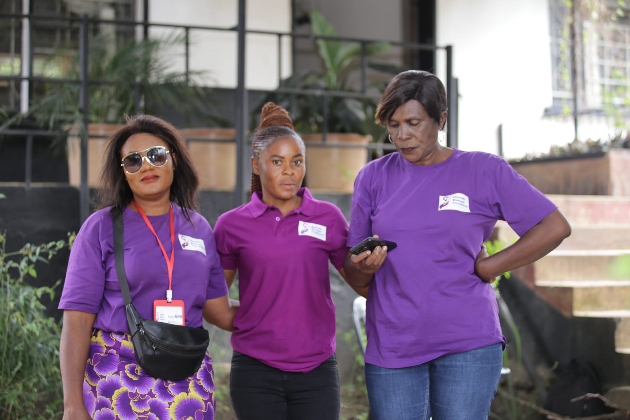 three volunteers in their purple uniform three volunteers in their purple uniform